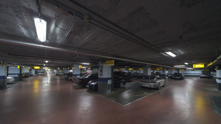 Coches aparcados a la luz de la iluminación de Philips en el aparcamiento de NH Hoteles
