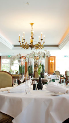 Dos comensales sentados a la mesa en el Restaurante La Rive, bajo las luces de iluminación para hostelería de Philips