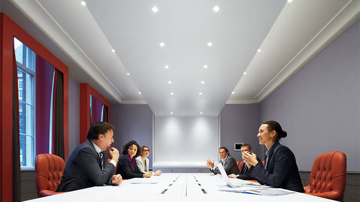 Asistentes a una reunión con iluminación para salas de reuniones de Philips