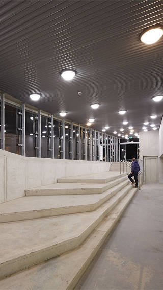  Hombre subiendo escaleras en el aparcamiento de Eiteren, iluminado con Philips Lighting 