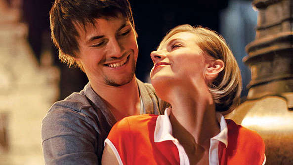 Una pareja feliz se abraza en una plaza bajo iluminación de Philips