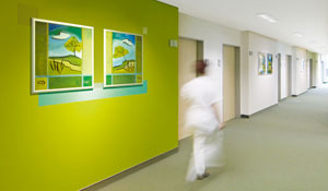 Enfermera caminando por el pasillo de un hospital verde 