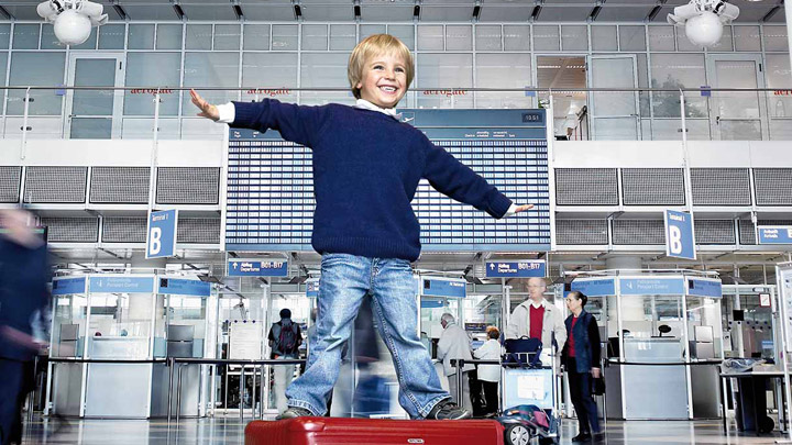 Niño feliz en una terminal de aeropuerto