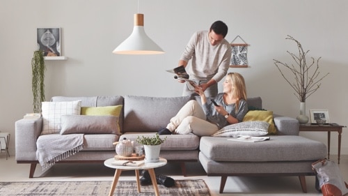 Dos personas sentadas en el sofá de casa disfrutando de una luz LED de gran calidad