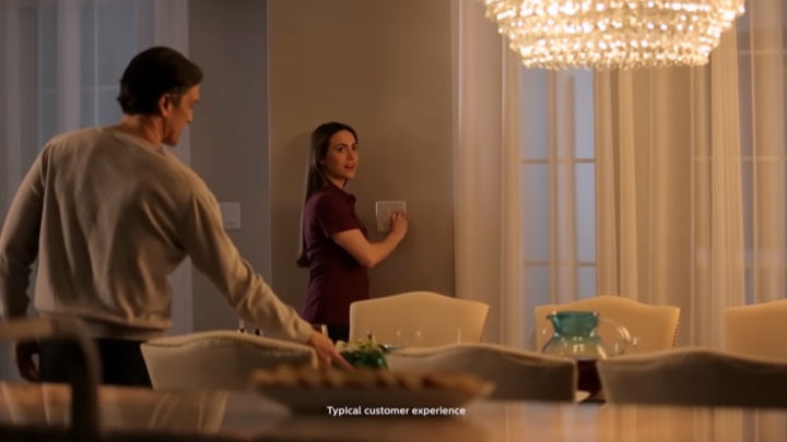 Mujer utilizando un interruptor inalámbrico para modificar el ambiente de una habitación