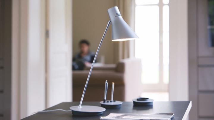 Lámpara de mesa en un escritorio orientada a la escritura
