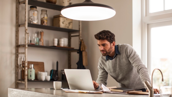 Un hombre que trabaja en casa a la luz de una lámpara inteligente