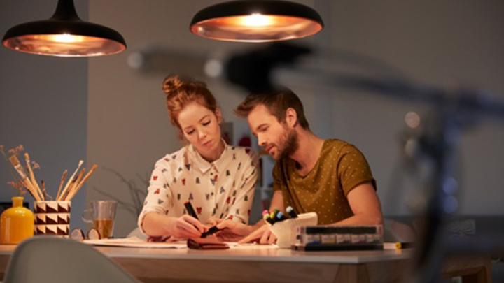 Dos personas elaborando un plan de iluminación en un escritorio bien iluminado