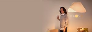 "Mujer que ajusta el interruptor inteligente de regulador, controlando el ambiente de iluminación LED cálida en el espacio de vida contemporáneo con un diseño minimalista"