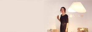 "Mujer que ajusta la iluminación LED empotrada brillante a través de un elegante regulador de montaje en pared, mejorando el ambiente y la eficiencia energética de la sala de estar moderna".