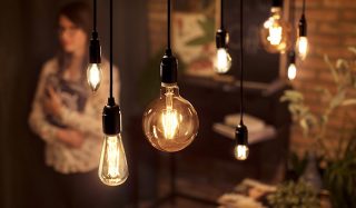 "Las bombillas de filamento LED de estilo vintage en formas variadas iluminan el área del comedor, creando un ambiente cálido y mostrando soluciones de iluminación decorativas energéticamente eficientes para interiores de hogares modernos".