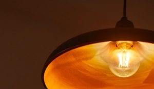 "Bombilla de filamento LED de estilo vintage en lámpara colgante, que emite un cálido resplandor dorado, que muestra una iluminación de estilo antiguo de bajo consumo para un ambiente hogareño acogedor".