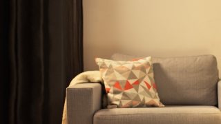 "Acogedora sala de estar con moderna lámpara de mesa LED, que ilumina el sofá gris y crea un ambiente cálido para la relajación del hogar."