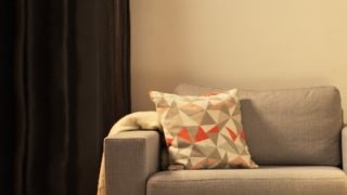 Acogedora sala de estar con moderna lámpara de mesa LED, sofá gris iluminado y creación de un ambiente cálido para la relajación en el hogar.